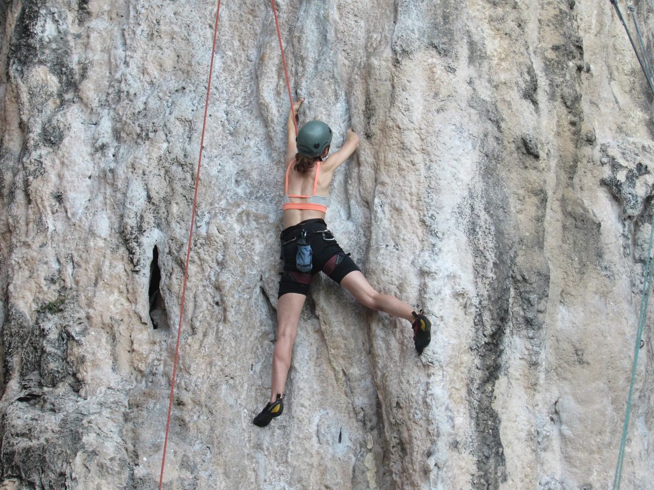 Rock climber ascending a limestone cliff, the same style of sport climbing found across Kalymnos's crags